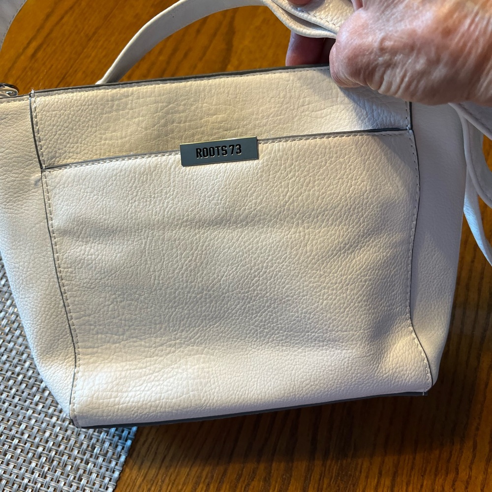 Elevate your style with this Roots white hand bag.